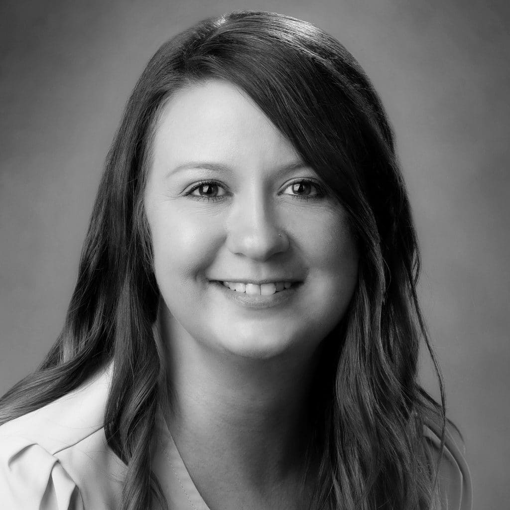 Black and white portrait of a woman with long hair and a pleasant smile.