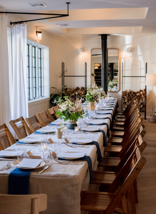 Elegant dining room with a long table set for a meal in a downtown Hudson historical renovation in Hudson, NY.